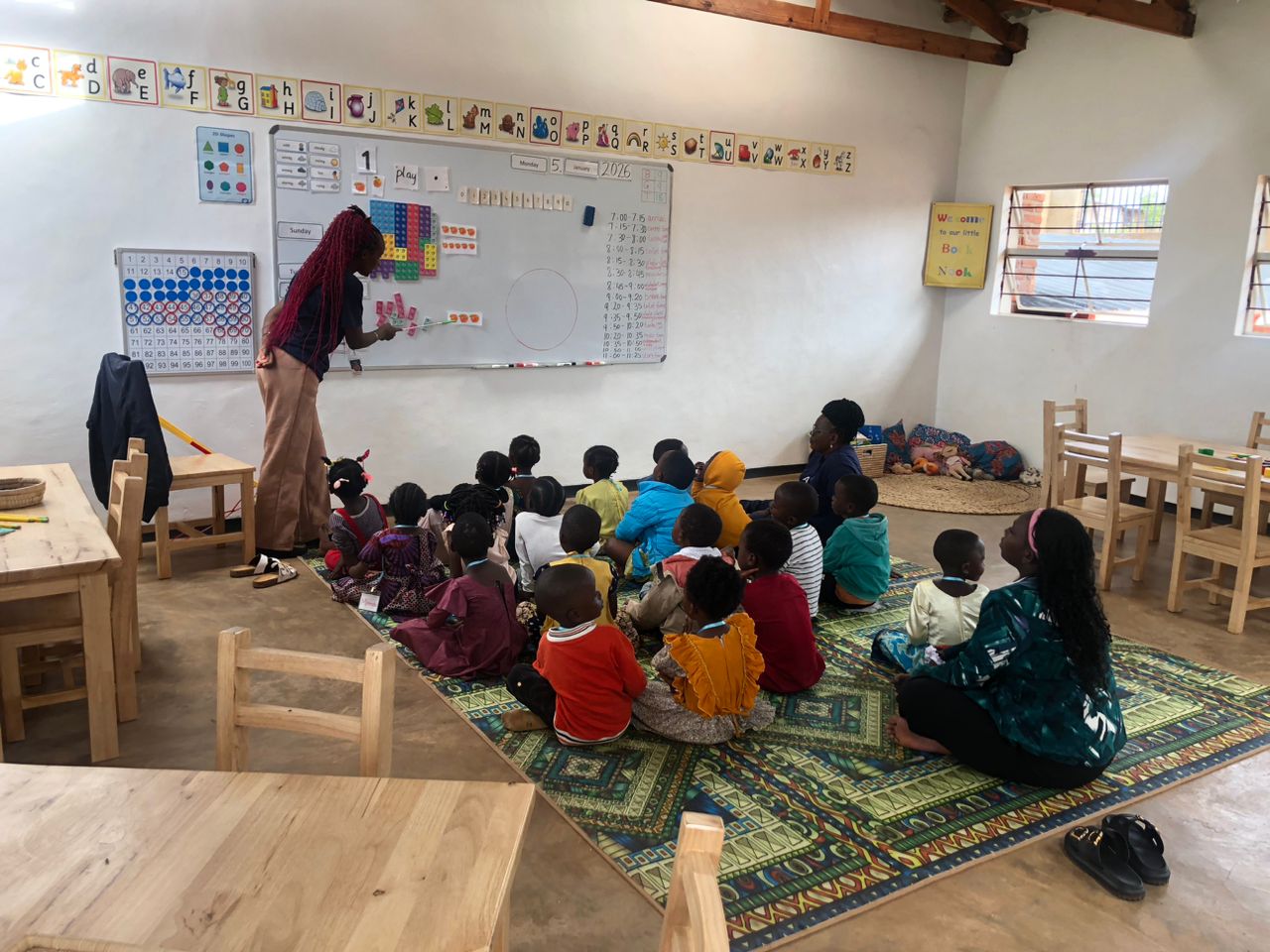 A teacher leads young learners inside a bright AVP classroom