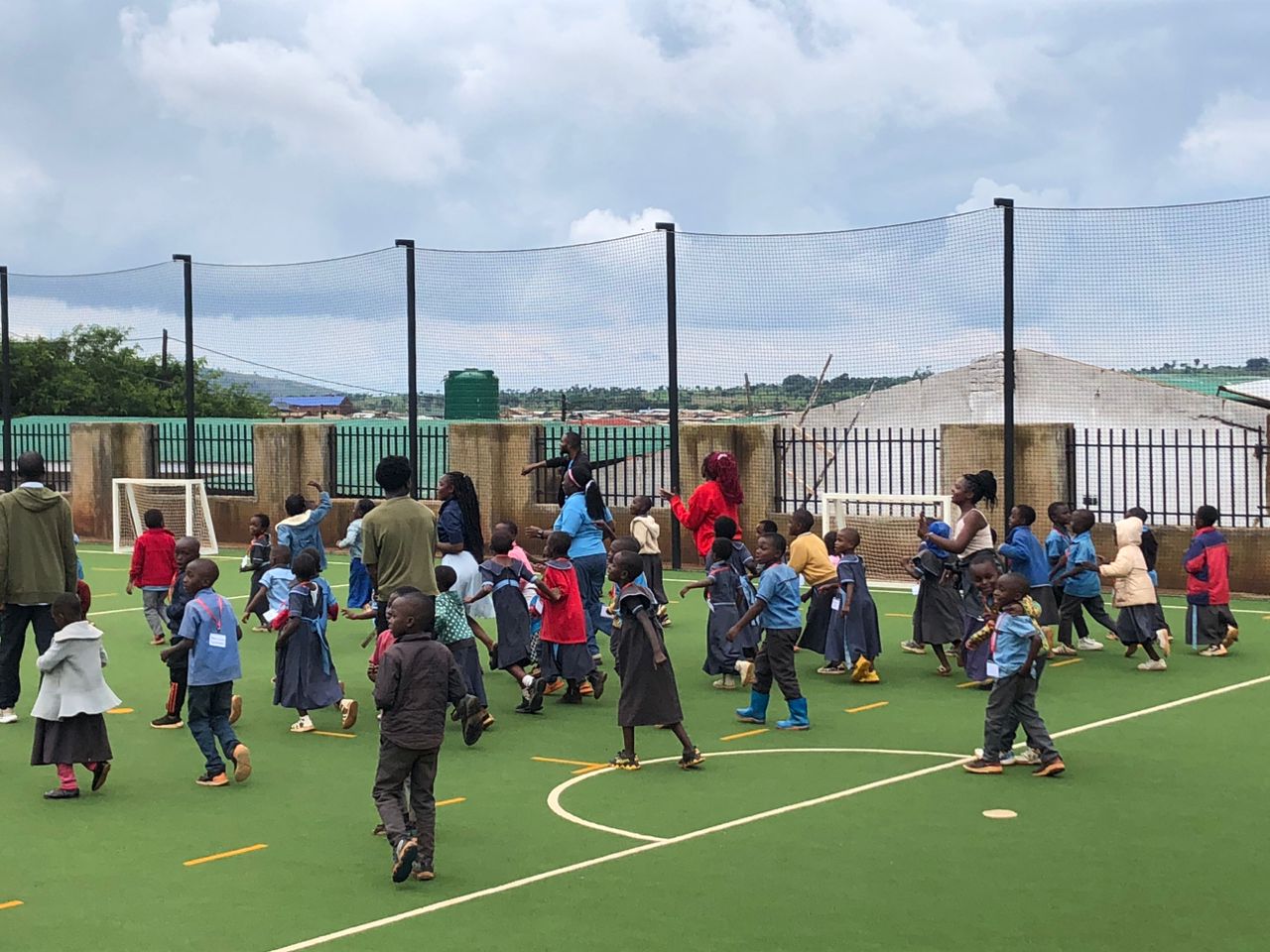 Children playing and running on the AVP sports court