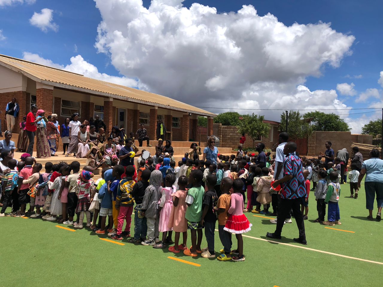 Community gathering in front of the learning centre buildings