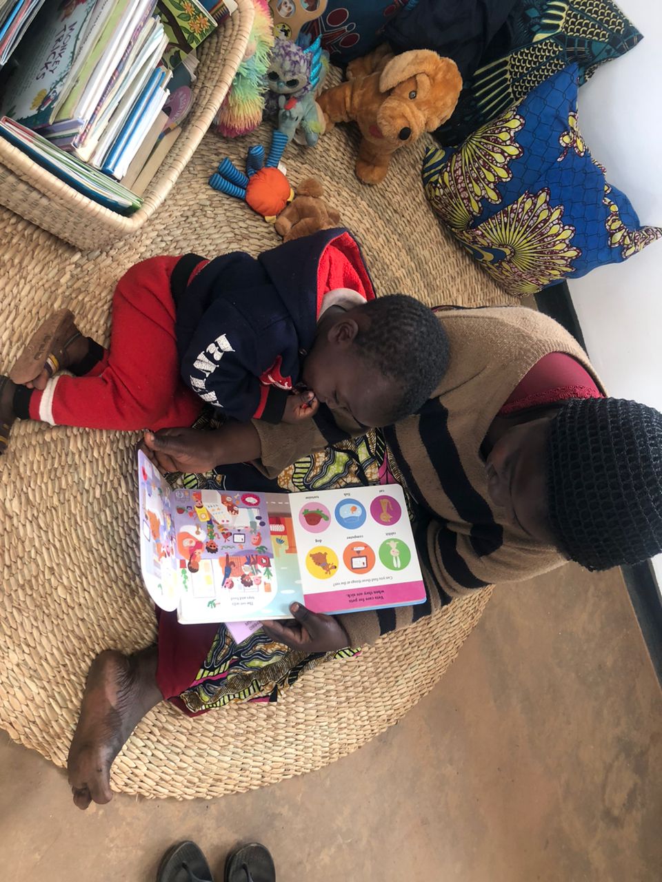A caregiver reads a picture book with a young child